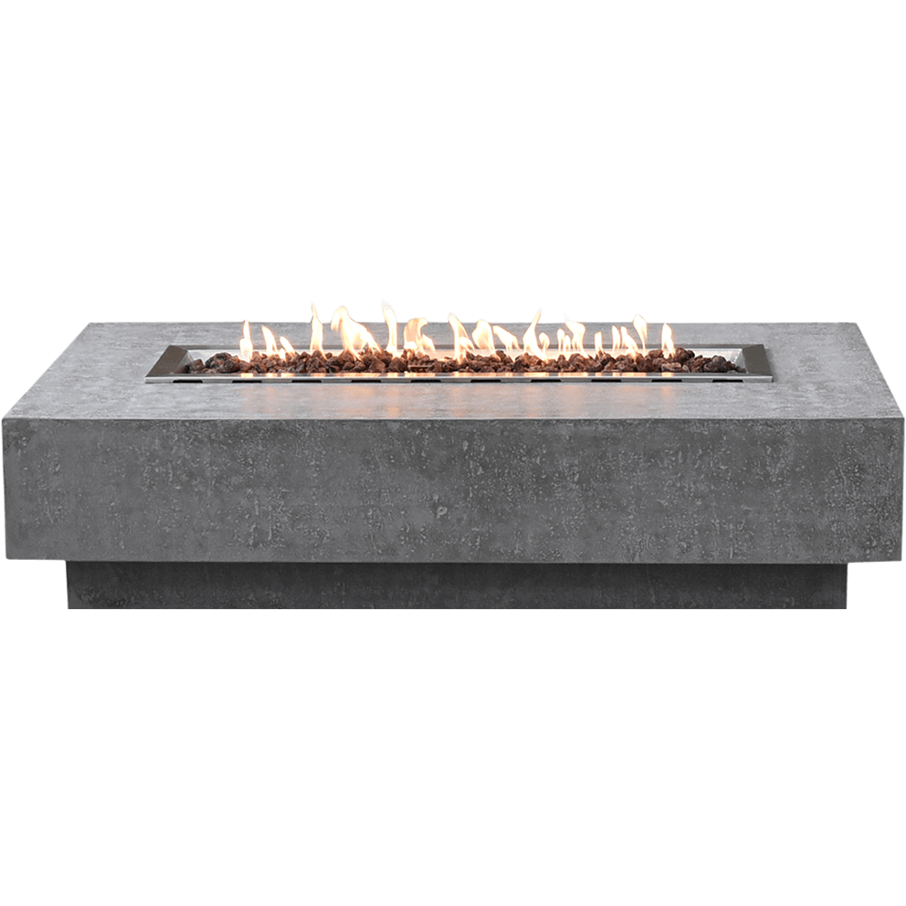 A front facing view of the Elementi Hampton Fire Table showing its long rectangular silhouette made from hand crafted glass fibre reinforced concrete in a light grey textured finish. The flat top surface extends evenly on all sides with a smooth edge that frames the central burner opening. The burner tray sits perfectly centred within the recessed rectangle and is filled with natural lava rock that forms a neat bed across the entire width of the opening. A continuous line of bright yellow and soft orange flames rises across the full length of the burner, creating an even ribbon of fire that highlights the subtle speckled detailing of the concrete surface. The lower base sits slightly inset beneath the main top, giving the fire table a floating appearance. The isolated product is shown against a clean black background, emphasising the straight lines, modern minimalist profile and premium construction of the Hampton Fire Table for both propane and natural gas configurations.