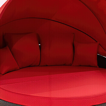 Close-up view of the Moon Bed Collection in the vibrant red fabric colour option. The image shows the round cushioned seating area with a matching retractable canopy, complemented by three large square pillows and one smaller pillow, all upholstered in the same bold red fabric. The intense red shade highlights the bold, modern aesthetic of this outdoor statement piece while emphasising its comfort and inviting design.