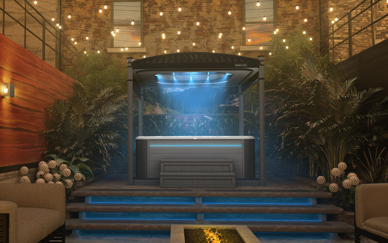 The Covana Oasis Midnight Edition automated hot tub cover, displayed in a luxurious patio setting with warm string lights and lush greenery. The matte black ribbed roof and frame contrast beautifully with the glowing blue interior LED lights. A dark grey hot tub with matching steps sits beneath, while the printed mountain and forest privacy screen completes the tranquil, nature-inspired aesthetic. The setting evokes an evening spa retreat in a private, stylish garden.