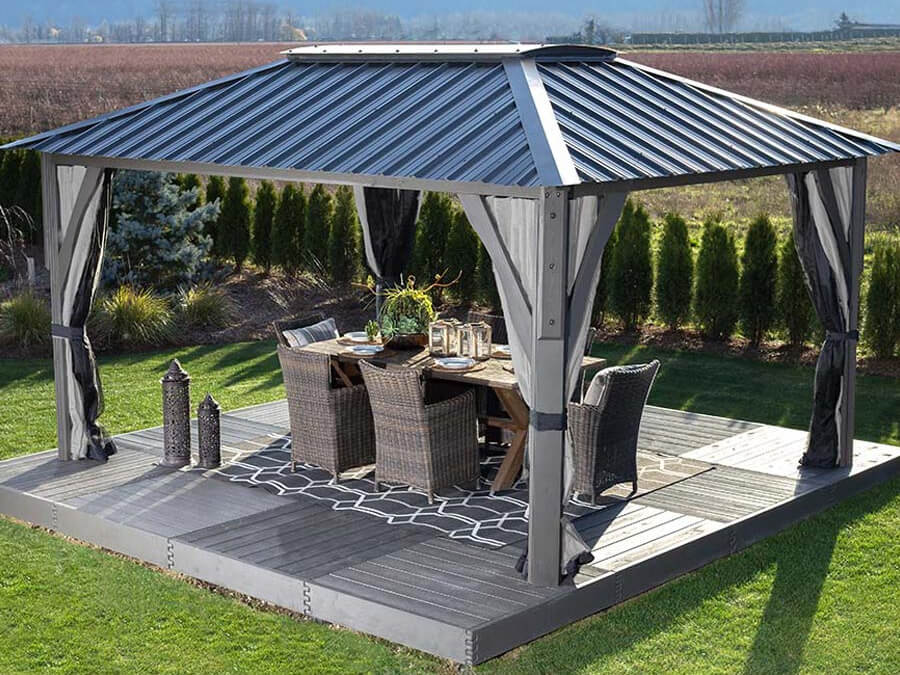 Close-up corner view of the Aluna gazebo, focusing on one vertical support post seamlessly connected to the overhead flat roof frame. The translucent roof panels above scatter sunlight, creating a bright but shaded effect underneath. The image emphasises the precision of the post-to-beam joints and the gazebo’s smooth, modern finish.