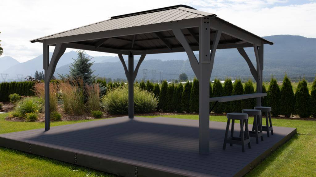 Evening view of the Aluna gazebo illuminated with warm ambient lighting beneath the roof. The translucent roof panels softly glow from integrated lights, while a patio set beneath provides a comfortable seating area. The background garden is dimly lit, highlighting the gazebo as a central focal point for night-time relaxation or entertaining.