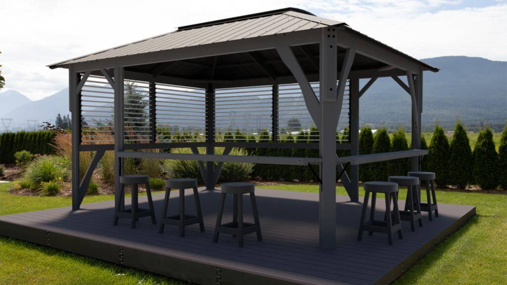 Wide daytime shot of the Aluna gazebo installed over a patio lounge area. The translucent roof panels cast soft, even shade across the outdoor seating beneath, which includes cushioned armchairs and a small table. The surrounding garden and stone patio flooring frame the gazebo, showing how it integrates seamlessly into a landscaped backyard.