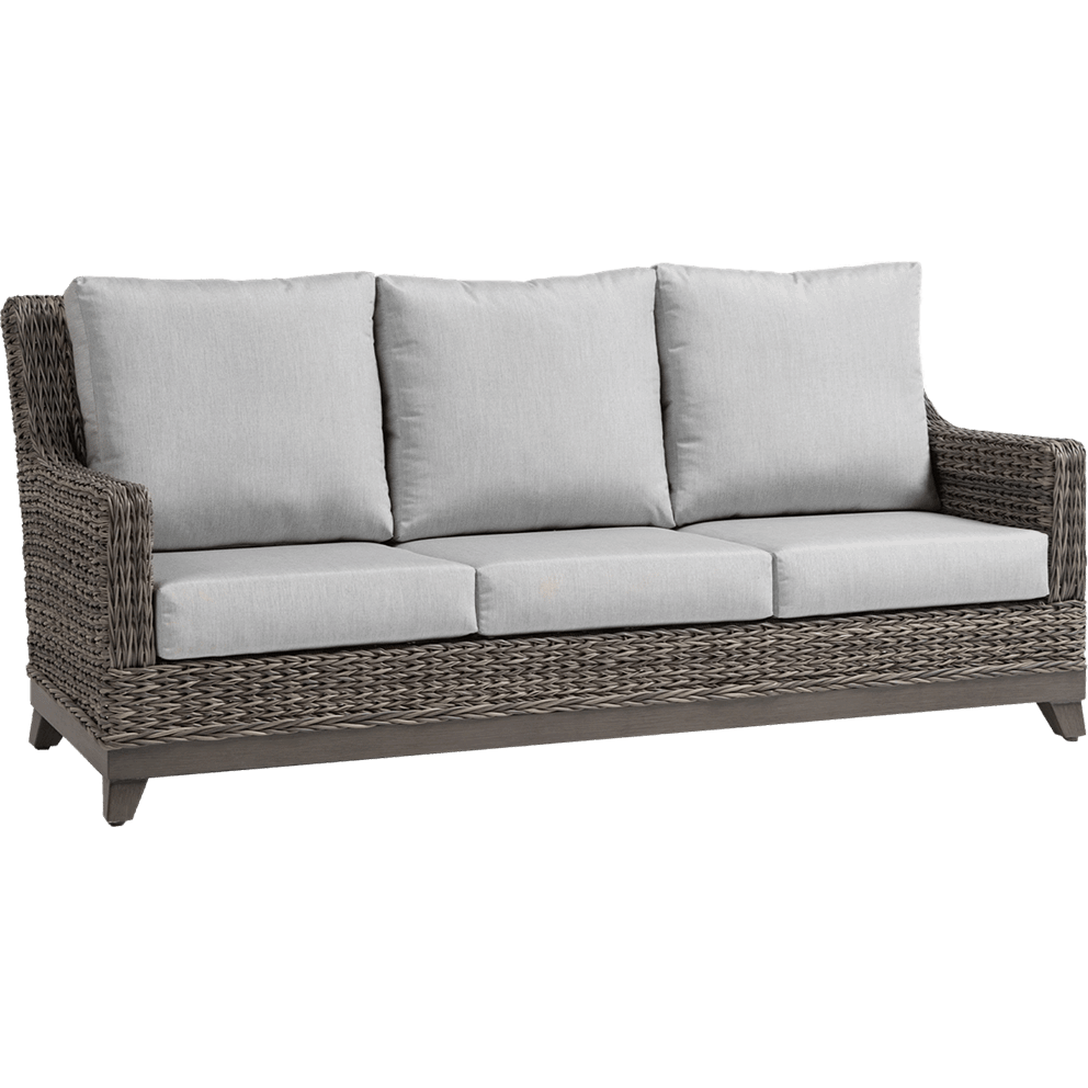 Outdoor Asheville Three Seat Sofa angled view showing hand-woven warm grey resin wicker frame with a deep seating profile. Sofa includes three thick Sunbrella seat cushions and three high-back cushions in soft light grey fabric, creating a modern yet natural look. Tapered dark wood-tone resin feet support the structure, while the slightly reclined backrest and low armrests enhance comfort and durability.