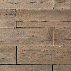 Close-up of the Cedar Brown colour option for the Bridgewood Fire Pit, showcasing elongated rectangular concrete blocks with a highly detailed woodgrain texture. The warm cedar-brown hue mimics the look of aged timber planks, with fine grain lines, natural knots, and subtle tonal shifts that give it the appearance of real wood, blending rustic charm with durable concrete craftsmanship.