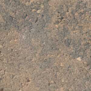 Close-up of the Sierra Grey colour option for the Caliber Stone Fire Pit, featuring a mottled surface of medium grey tones blended with warm tan and soft brown flecks. The natural stone texture appears slightly rough and weathered, evoking the earthy look of quarried rock ideal for rustic or modern outdoor settings.