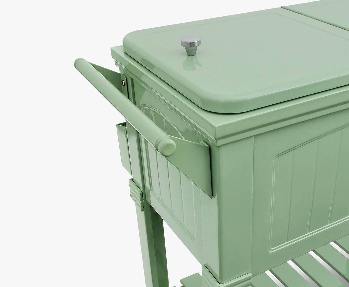 Close-up side view of the Permasteel 80qt Furniture Style Cooler in sage green. The image highlights the smooth powder-coated steel finish with moulded panel detailing. A wide handle extends from the side, matching the cooler’s soft green tone. The photo focuses on the craftsmanship and texture, showing clean lines and subtle contours that reflect its modern yet vintage-inspired design.
