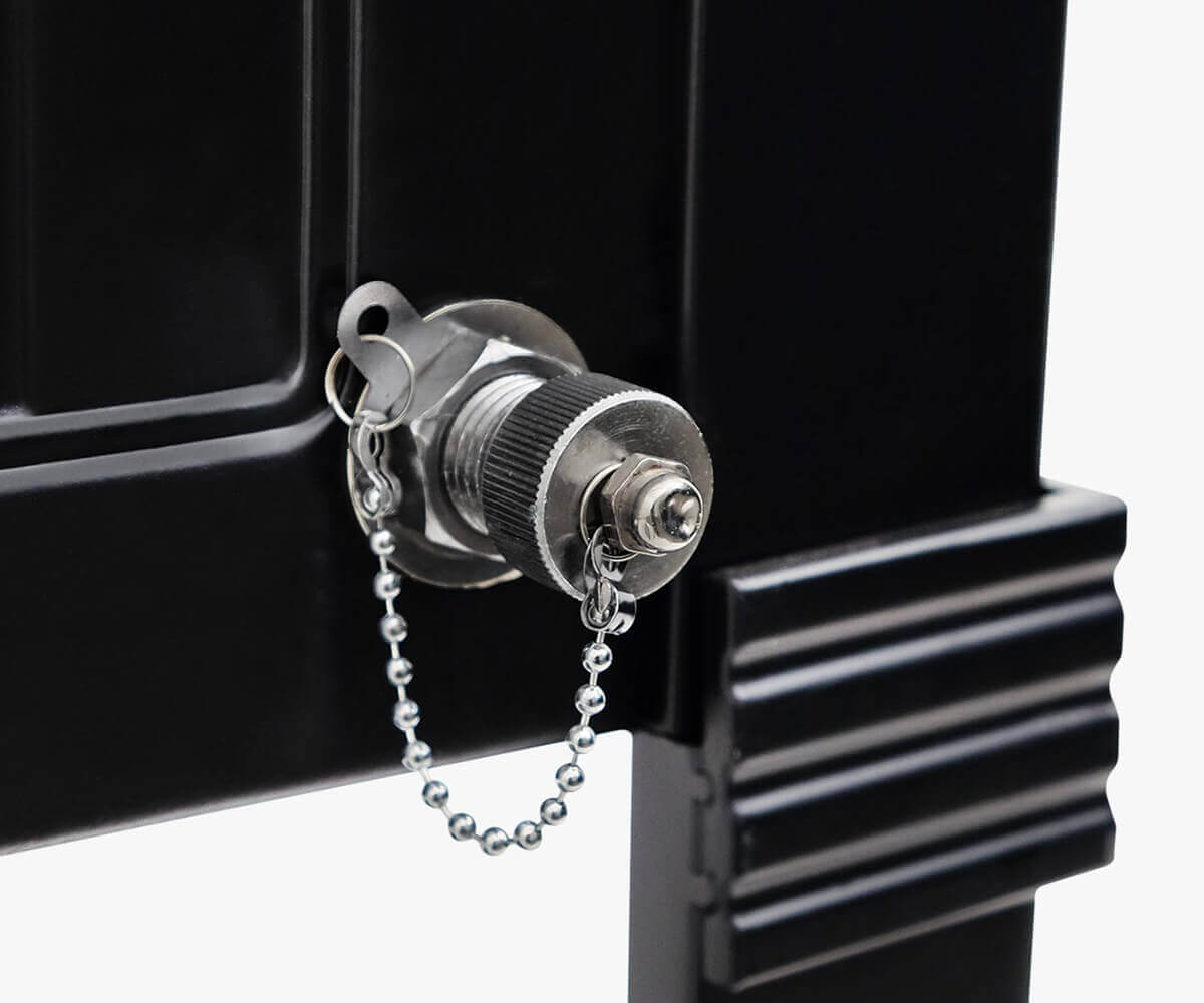 Extreme close-up of the Permasteel 80qt Furniture Style Cooler’s chrome drain plug on a black body. The metal plug features a textured grip and a small bead chain attached for security. The surface detailing of the black powder coating and ribbed corner column reveals the cooler’s sturdy, weather-resistant build, balancing function and style.