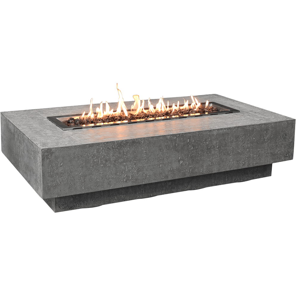 A product isolated view of the Hampton fire table shown on a white background with the burner lit. Bright orange flames rise evenly along the stainless steel burner tray filled with reddish brown lava rocks. The rectangular table displays its signature light grey textured concrete finish with a clean stepped base. The lit burner casts warm reflections across the upper surface, emphasising the fire feature as the focal point.