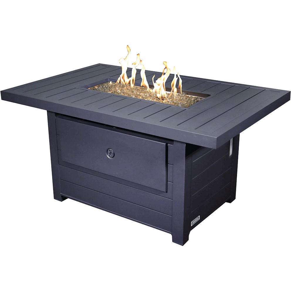 A clean isolated product image of the Sunbeam Serenity Fire Table against a transparent background, captured at a three quarter angle. The matte black aluminum tabletop has long horizontal slats that frame the recessed rectangular burner opening, which is filled with clear decorative flame glass. Bright golden flames rise in multiple irregular shapes from the stainless steel burner beneath the glass, creating warm reflections across the surrounding slats. The edges of the tabletop are thick and sharply defined, sitting above a sturdy base constructed of matching vertically slatted panels. The front access door is centred on the base and designed to conceal the propane tank, while small adjustable feet barely visible below provide balance and alignment on uneven surfaces.