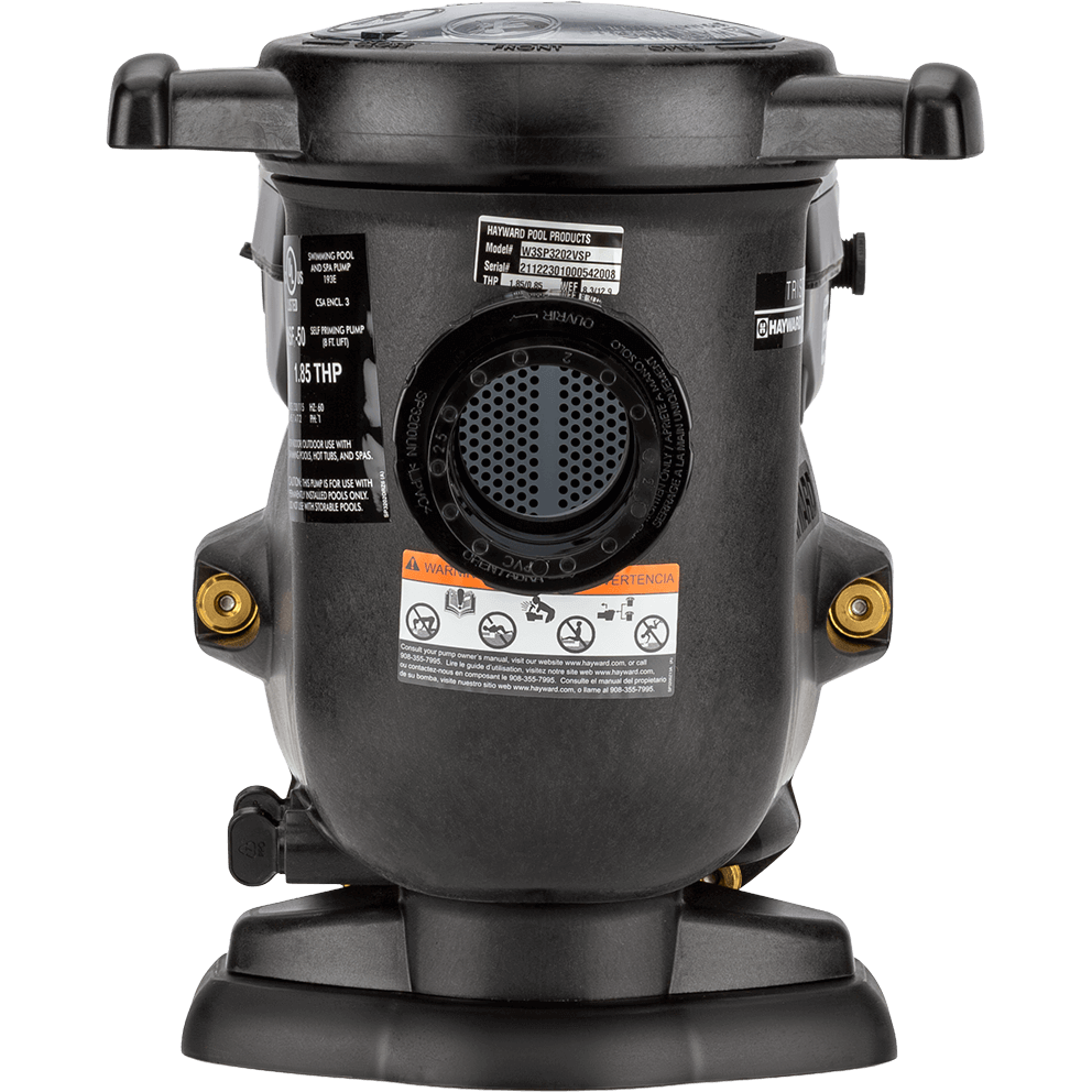 Front facing view of the Hayward TriStar VS Variable-Speed Pool Pump, isolated on a transparent background, showing the strainer pot end head on. A large circular opening sits in the centre with a perforated inner surface visible through it, framed by a thick ring. Above, the round strainer lid spans the top with two opposing side tabs, and the tall vertical discharge outlet rises behind the lid at the top centre. On the lower front of the housing, a wide orange and white warning label band runs horizontally. Brass toned inserts appear on both sides near mid height, and the heavy black base foot sits at the bottom with a broad, rounded front edge.