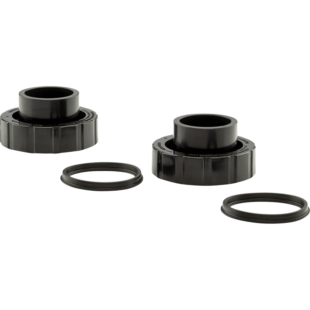 Isolated product view of two Hayward MaxFlo XL pump union fittings and two matching O-ring gaskets displayed against a transparent background. The two black plastic union fittings are positioned horizontally across the image, one on the left and one on the right, each featuring a wide, ribbed locking nut at the base and a short cylindrical pipe socket extending upward from the centre opening. Below and slightly offset from each union fitting is a flat, circular rubber O-ring, laid flat to show its round shape, consistent thickness, and smooth sealing surface. The components are evenly spaced and clearly separated, allowing the threaded union design, connection openings, and sealing gaskets to be clearly distinguished for use on the MaxFlo XL pump’s inlet and outlet connections.