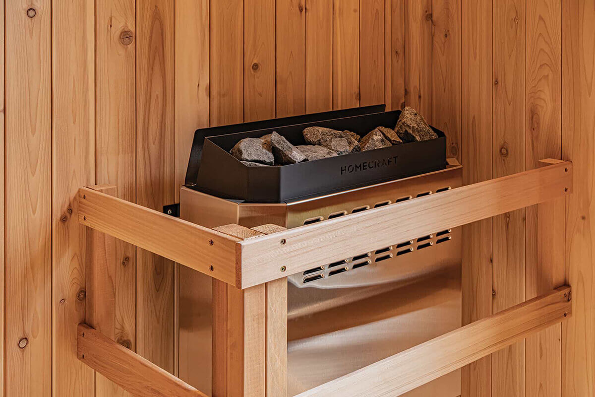 9kW Homecraft heater in the Visscher Luxe Sauna: Close-up of the stone tray and cedar guard rail. Reaches traditional sauna temperatures of 90°C.
