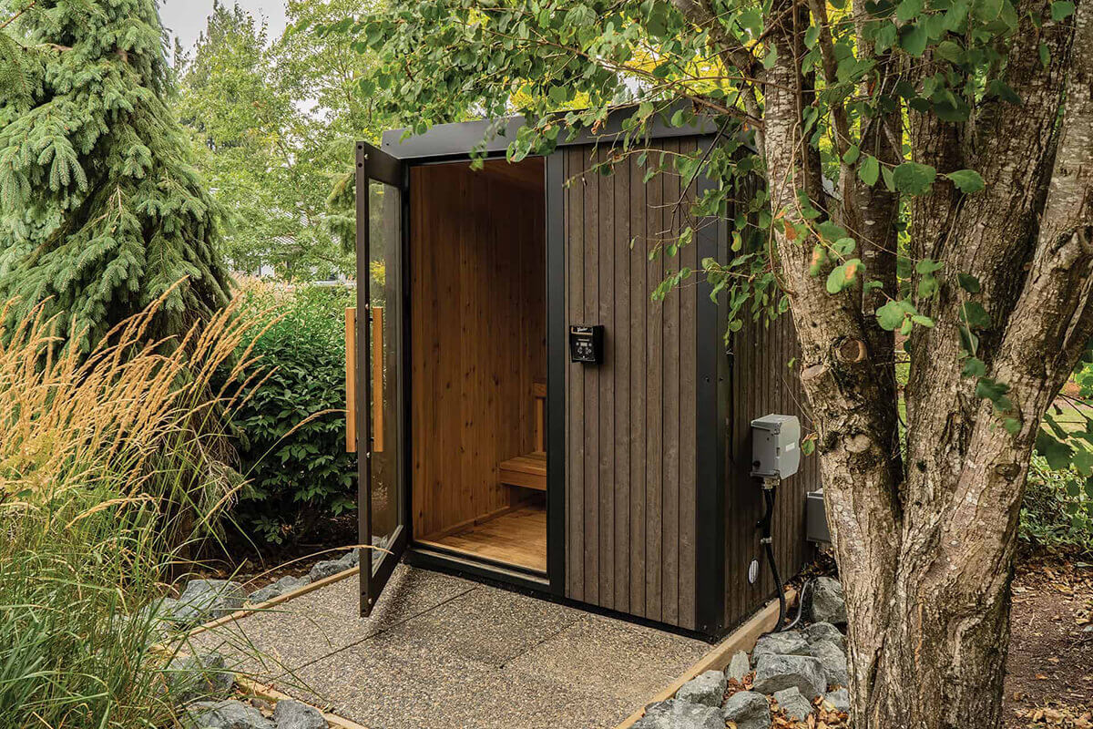 Visscher Luxe Sauna at Crown Spas & Pools: Outdoor angled view with open door showing electrical connection and durable grey wood exterior cladding.