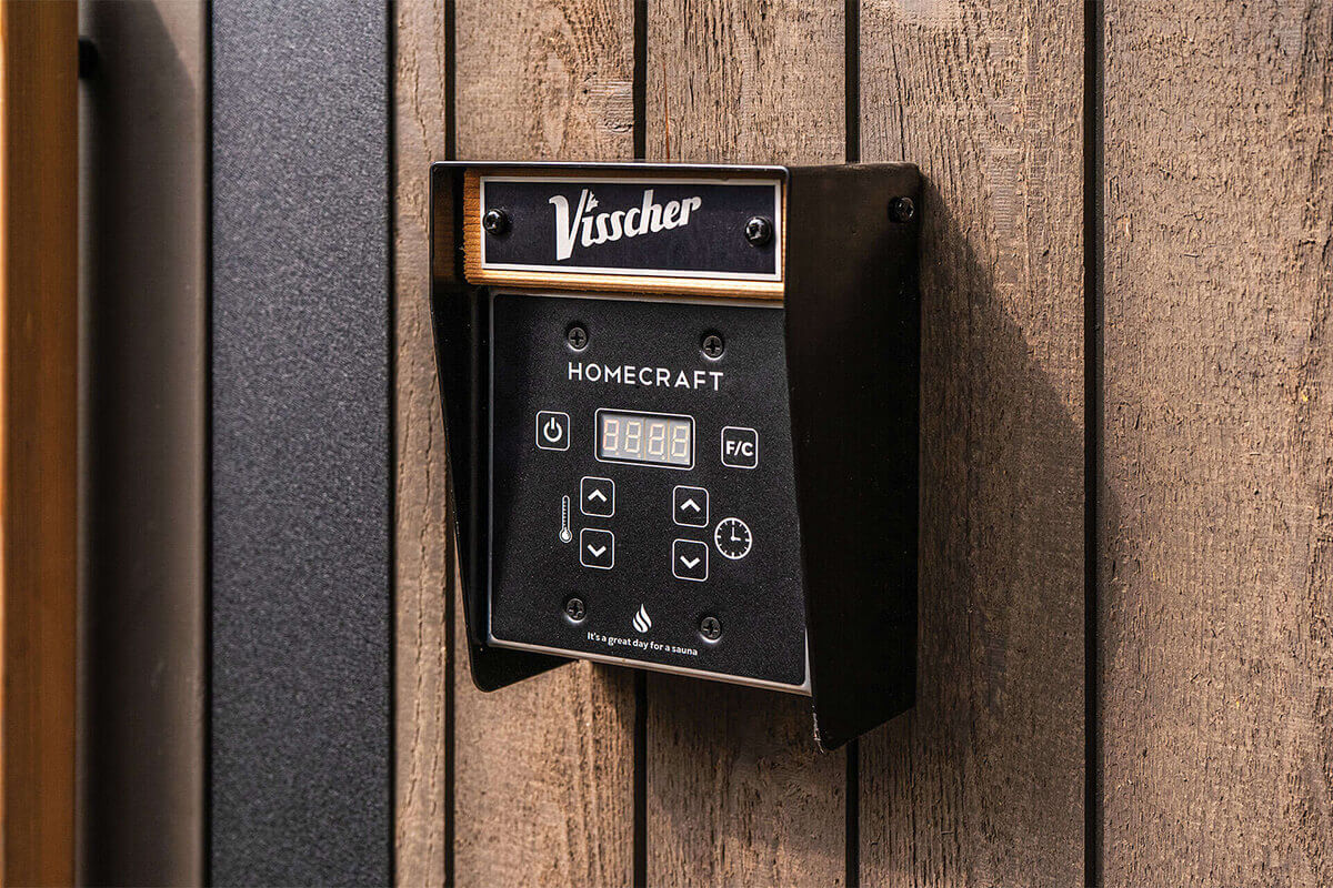 Visscher Luxe Sauna control panel: Close-up of the Homecraft digital interface for temperature and timer settings on the grey wood exterior wall.